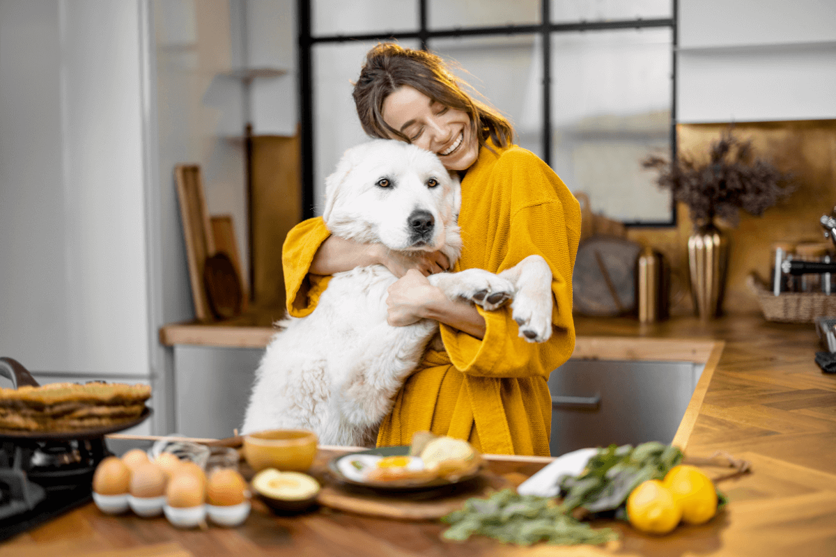 Mulher feliz com cachorro preparando comida